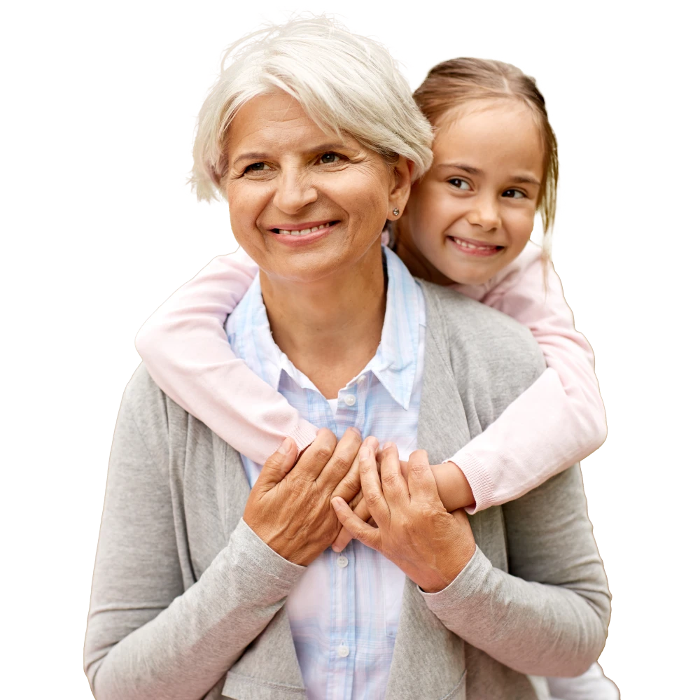 Smiling older woman being hugged from behind by a cheerful young girl