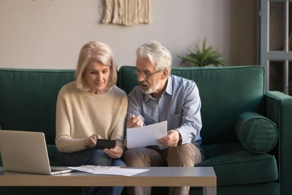 A middle-aged couple talking on a sofa