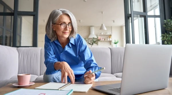 Woman researching prepaid burial plans on a laptop