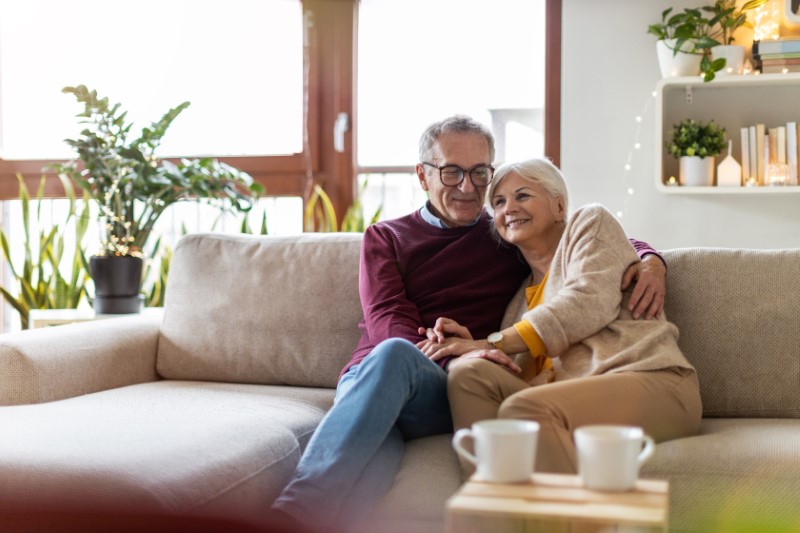 Portrait of a happy senior couple relaxing together at home on the sofa